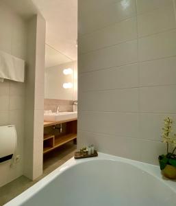 米明伊丽莎白公寓酒店的浴室配有白色浴缸及水槽