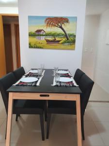 马塞约Rosa Branca Facilities Apartamentos的餐桌、椅子和墙上的绘画
