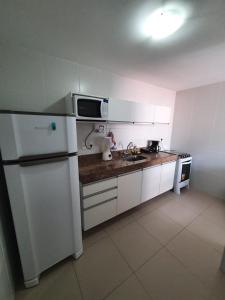 马塞约Rosa Branca Facilities Apartamentos的厨房配有白色冰箱和水槽