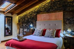 特格斯特Casa Doña Justa的一间卧室配有一张带红色枕头的大床