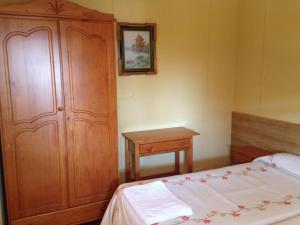 Cubillas de Santa MartaCamping Cubillas的一间卧室配有木制橱柜、一张床和一张桌子