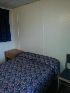 阿弗内尔美洲汽车旅馆的一间卧室配有一张床和一把椅子