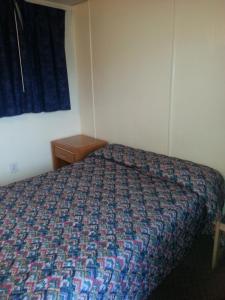 阿弗内尔美洲汽车旅馆的一间卧室配有一张带彩色床罩的床