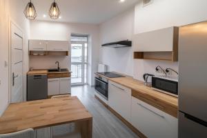 奥普尔Around the World Vision Apartment - Centrum的厨房配有白色橱柜和木制台面