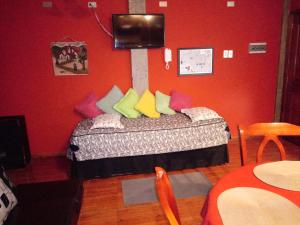 蓬塔阿雷纳斯VALYAK rent apart hotel - Servicios Integrales的一间卧室配有带色彩缤纷枕头的床。