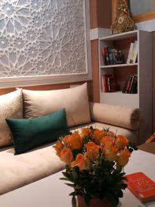 马拉喀什里亚德乔恩波尔摩洛哥传统庭院住宅的一张桌子上带橘子花的长沙发