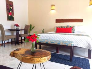 巴利亚多利德Mayan Majesty Boutique Hotel的一间卧室配有一张床和一张花瓶桌子
