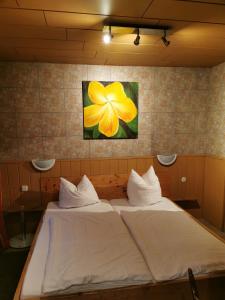 凯撒斯劳滕See Lord Hotel的墙上有一朵黄色花的房间里一张床位