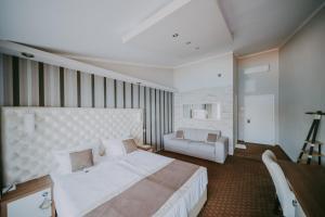 斯塔拉巴斯卡Rooms Nadia的卧室配有一张白色的大床和一张沙发。