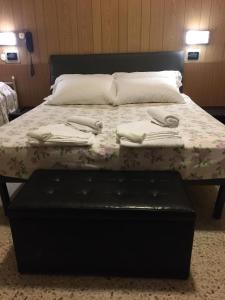 里米尼佐丹奴斯皮亚贾格酒店的一张带花卉床罩和毛巾的床