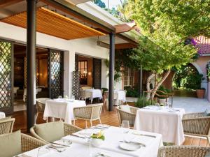 洛杉矶Hotel Bel-Air - Dorchester Collection的户外餐厅设有白色的桌椅