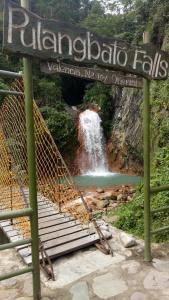 杜马格特Pulangbato Falls Mountain Resort的瀑布背景,前面有标志