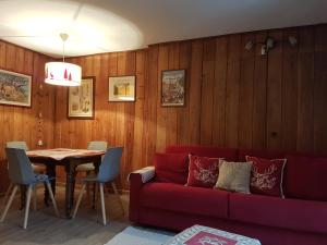 库马约尔花园公寓的客厅配有红色的沙发和桌子