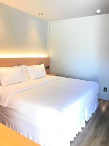 邦劳Mayfair Resort的卧室配有白色床单和白色大床