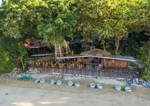 俊穆岛Koh Jum Ocean Beach Resort的海滩上的餐厅,配有桌椅