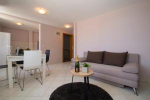 科尔丘拉MILINA KORČULA的客厅配有沙发和一张桌子及一瓶葡萄酒