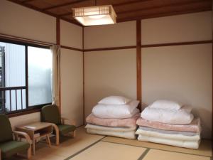 高野山Guest House hachi hachi的客房设有两张床、一把椅子和窗户。