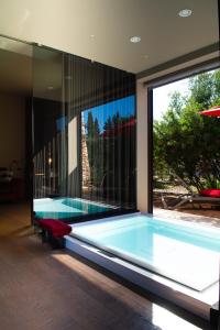 曼杜里亚Masseria Li Reni的一座带大窗户的房屋内的游泳池