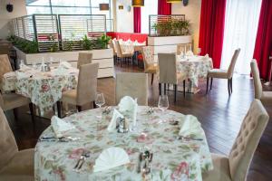 RóżanHotel Avangarda的一间配备有桌椅和红色窗帘的用餐室