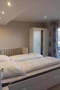 诺德堡Augustenhof Ferien的一间卧室配有一张带白色床单的大床