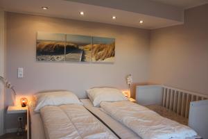诺德堡Augustenhof Ferien的卧室内的两张床,墙上有两幅画