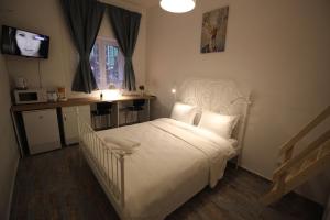 布拉索夫92 Residence的卧室配有白色的床和电视。