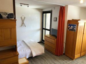 萨莫安斯Les Cimes的一间卧室配有一张床、一个梳妆台和一扇窗户。