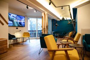 基茨比厄尔Roomie Alps Design Hostel的客厅配有黄色椅子和平面电视