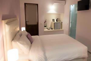 干尼亚Shalom Luxury Rooms Kondilaki的一间卧室配有带白色床单和枕头的床。