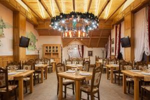 布克维Ganz SKI Lift 5的餐厅设有木桌、椅子和吊灯。