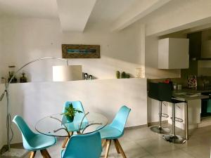 穆斯捷-圣玛丽La Maison du Courtil, Pistache-Chocolat的厨房配有玻璃桌和蓝色椅子