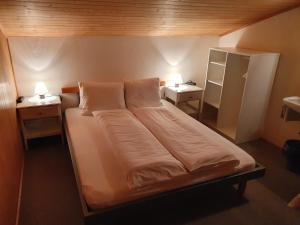 芙露姆赛山贝格海姆餐厅酒店的一张位于带两张桌子和冰箱的房间的床位