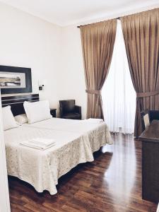 马德里梅耶旅馆的一间卧室设有一张大床和两个大窗户