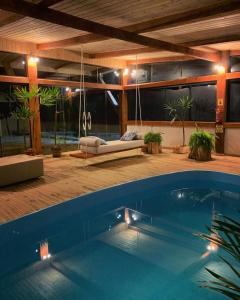 邦雅尔丁-达塞拉法泽恩达圣塔里塔农场旅舍的一座带秋千的房屋内的大型游泳池