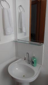 费拉迪圣安娜Plaza Fraga Maia的浴室配有盥洗盆、镜子和毛巾