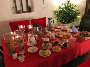 尼希施泰因豪斯集市酒店的一张桌子,上面有红色的桌布,上面有食物和圣诞树