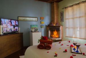 维奥康德马奥Pousada Bolo Húngaro的一间卧室设有一张玫瑰床和一个壁炉