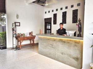 暹粒Cozy Boutique Villa Siem Reap的坐在餐厅柜台上的男人