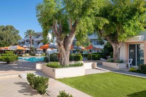塞奥洛戈斯梅利酒店的一座带游泳池和树木的度假村和一座建筑