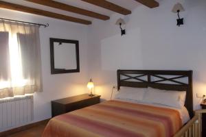 Las Cuevas de CañartCasa Rural El Temple的一间卧室配有一张床、镜子和窗户