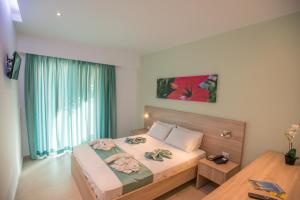 塞奥洛戈斯梅利酒店的一间卧室配有一张带粉红色鲜花的大床