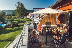 伏尔塔瓦河畔利普诺里普诺湖度假酒店的一群人坐在阳台上的桌子上
