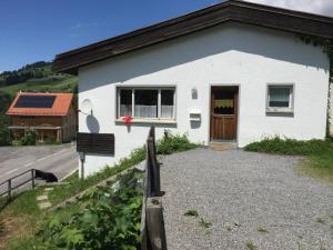 拉特恩斯Berg & Skihütte -Schmittenhof的白色的建筑,有棕色的门和一条路