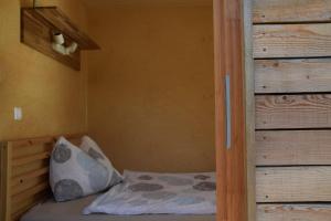 奥西阿赫Tiny Häuschen的木墙客房内的小床