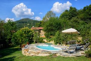 RossanaCasetta nel Bosco Naturas con piscina privata e gratuita的一个带两把椅子和遮阳伞的游泳池