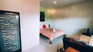 班帕那普兰โรงแรมฟร้อนบีช frontbeach的一间卧室配有一张小床和粉色毯子