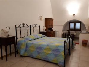 莫托拉Masseria Cassiere的一间卧室配有一张带五颜六色棉被的床