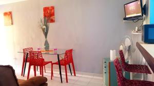 圣安娜HAMEAU DE BEAUREGARD的一间带桌子和红色椅子的用餐室