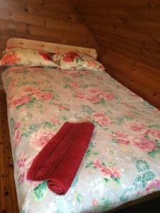 Lautere列列库普利度假屋的一张带花卉床罩和两个红色枕头的床