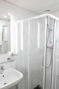 阿姆斯特丹多利亚酒店的带淋浴和盥洗盆的白色浴室